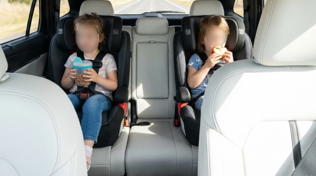 children eating snacks in the back seat of a hire car