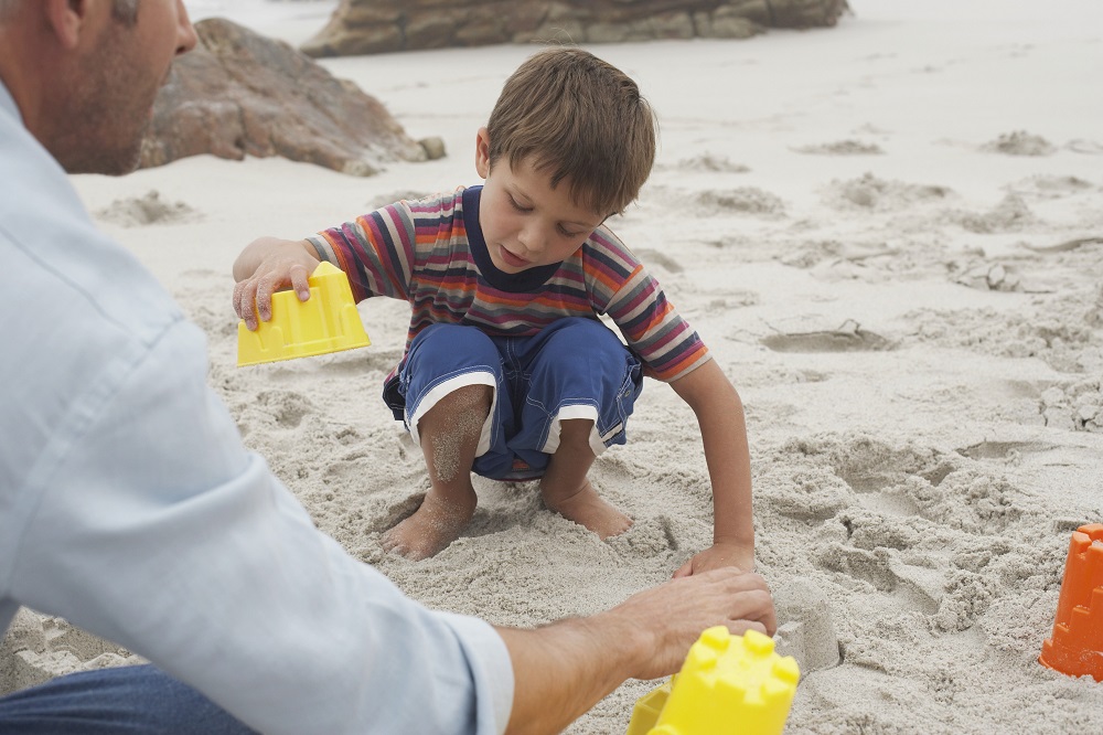 child playing in the sand at the beach